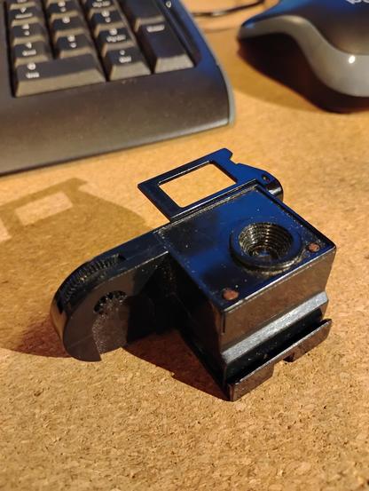 A tiny camera that snaps around a roll of 110 film. It's about 2/3 the size of the film cartridge (not shown) at 2.5 by 1 by 1 inches -- 1.5 inches with the useless viewfinder flipped up. 