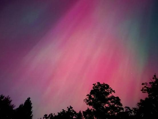 Magical

This evening, October 10, 2024, at 7:30 pm at my home in southern Maine. My wife came in from outside and said, quick, come outside. She had seen the northern lights years ago and she knew it was something I really wanted to see. I stepped outside and was amazed by the sky. It was a glowing bright red, and then slowly started to move and colors jumped around. It was magical, I was in absolute awe. I didn't have time to jump into my car and drive somewhere that I could compose a better picture. I was more than happy to just watch it from my little house in the woods and capture it above the trees.