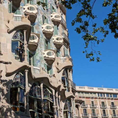 Rounded balconies sticking out of the facade of casa botllo against a blue sky. 