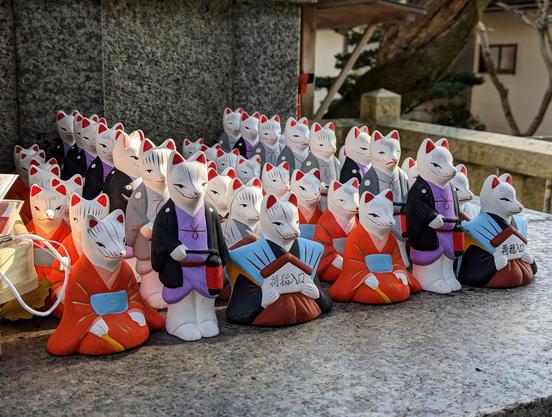 Kimono clad clay foxes, messengers of the god Inari.