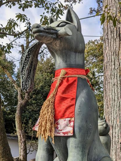 A fox statue at Fushimi inari wears a head of ripened rice around its neck. Inari is considered (amongst other things) to be the god of rice.