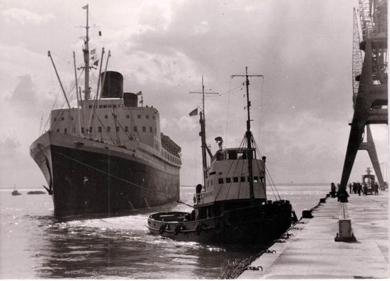...That was between 1958 and 1966. When I was little, I watched the confetti departure of the "Hanseatic" to NYC. I stood before that mighty big steel ship and as a little boy I was really impressed, and I waved it good bye.

The picture shows the "Hanseatic" arriving at harbor "Steubenhöft" in Cuxhaven (Germany, coordinates 53°51′40″N 08°41′40″E), pulled in by a tug. On the right there are standing big cranes for unloading the old style freighters, on the left the bows of the ship and the tug are seen in the waters of the Elbe river.

The sky seemed cloudy, water was calm.

The photography is from my grandparents´ collection.

More info for the "Hanseatic" (the first ship of that name then) are in:

https://de.wikipedia.org/wiki/Hanseatic_(Schiff,_1930)

The time referenced in the picture is in 

https://de.wikipedia.org/wiki/Hanseatic_(Schiff,_1930)#Hanseatic

Have a peaceful, healthy, and happy day!

