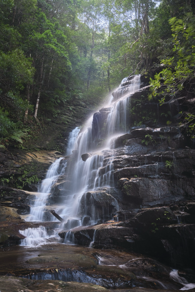 Waterfall cascading over rocks in a forest. 