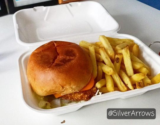 Takeaway container with vegan chicken burger and a helping of chips