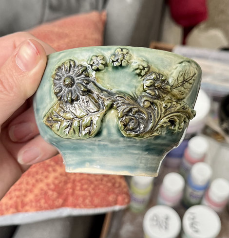 Small blue bowl with brown/green metallic floral carving 