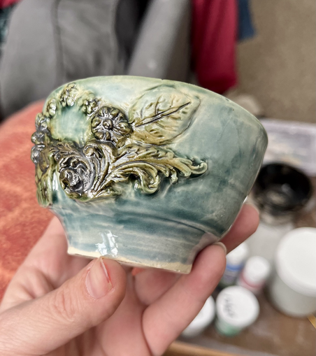 Small blue bowl with brown/green metallic floral carving 