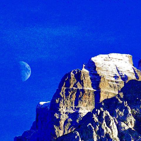 Bild eines Gipfels mit den Mond daneben.