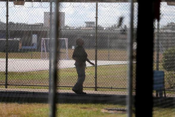 In this Sept. 26, 2019 file photo, a guard walks on a path between yards during a media tour inside the Winn Correctional Center, in Winnfield, La. The number of detainees nationwide has more than doubled since the end of February 2021, to nearly 27,000, according to recent data from U.S. Immigration and Customs Enforcement. (AP Photo/Gerald Herbert, File) © AP