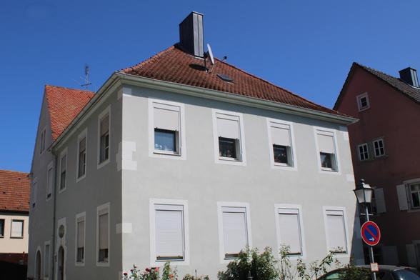 Ein unscheinbares hellgrau-weißes Gebäude. Die Fenster sind mit Rollläden verschlossen (unten alle zu, oben alle halb geschlossen). Hier befand sich einst die Synagoge.