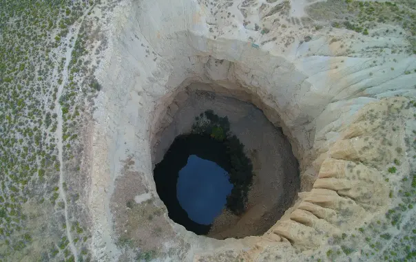 Sima de San Pedro de los Griegos, a giant sinkhole between Oliete and Ariño, Teruel, Spain. It houses a colony of several bat species. The pond on the bottom is connected to the Río Mártin. 