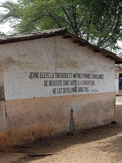 Photo d'un mur d'école de Cotonou au Bénin qui dit: jeune eleve, la tricherie et autres formes similaires de réussite sont aussi la corruption.ne les developpe donc pas.