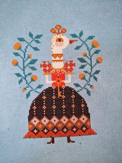 A chicken standing person-like in a fancy dress with a bell-shaped skirt holding a key in front of her. Yellow flowering plants frame her on each side.