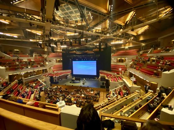 Grote Zaal, piano, scherm, de stoelekes vullen zich…