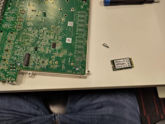 A Netgate 6100 router main board with a new SSD on the table.