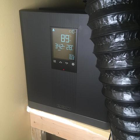 An AC Infinity Thermoforge T3 heater on a shelf with some flex tube dangling in front of it.