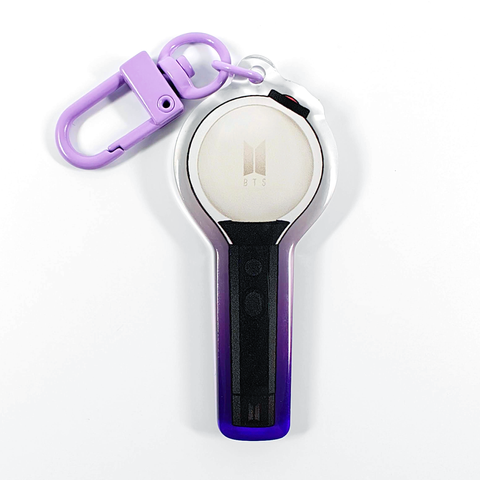 A picture of an acrylic keychain of a drawn version of BTS' newest lightstick. The rim of the keychain has an ombre that goes from purple at the bottom to clear at the top. It has a light purple clasp.