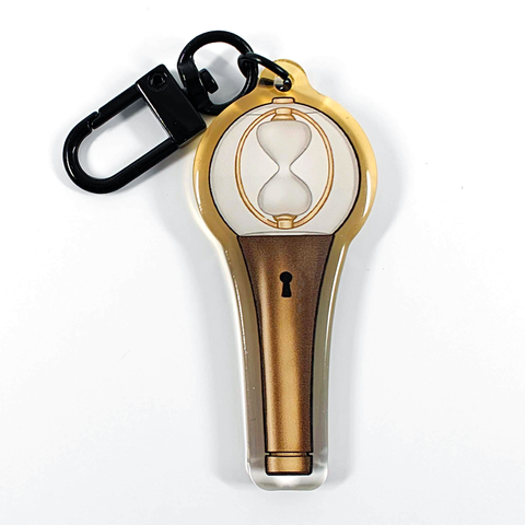 A picture of an acrylic keychain of a drawn version of ATEEZ's newest lightstick. The rim of the keychain has an ombre that goes from clear at the bottom to golden at the top. It has a black clasp.