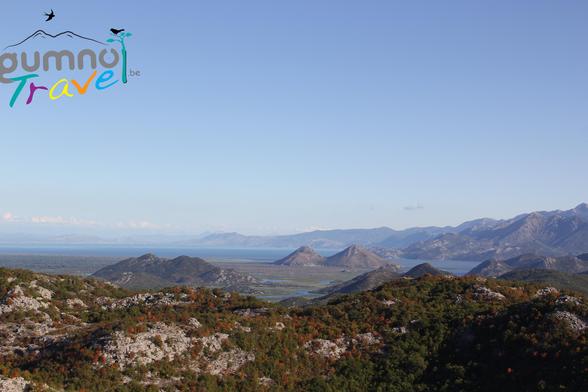View over Skadar Lake in Montenegro, direction Albania. Sunset already starting over the rocky hills, topped with green bushes, and in the distance the dark blue water of the lake.