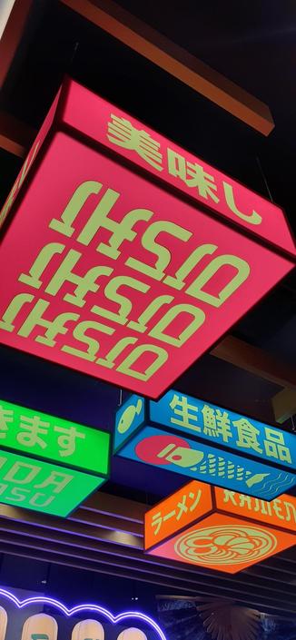 Decoración asiática en el techo, con cajas de luces de colores con textos japoneses.