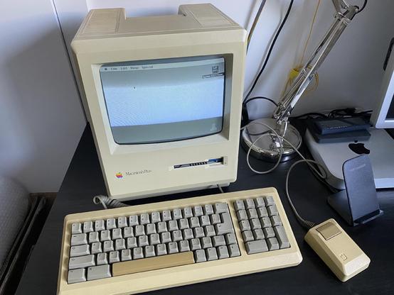 Picture of a Macintosh Plus with keyboard and mouse sitting on a desk.