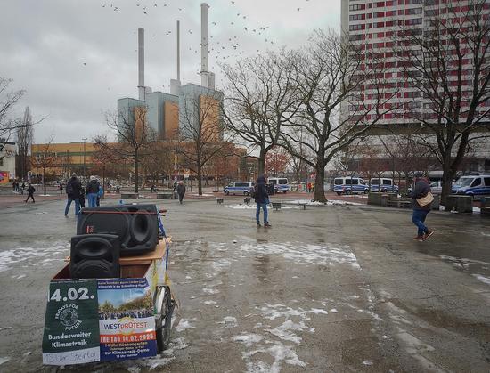 Am Küchengarten, vor der Demo. Links unten Wägelchen mit Plakaten, "bundesweiter Klimastreik" "Westprotest". Hintergrund Kraftwerk. Rechts Ihmezentrum. 5 Wannen in blauweiß.