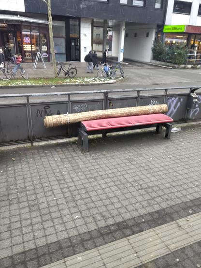 Foto eines eingerollten Teppichs auf der Bank einer Tramhaltestelle
