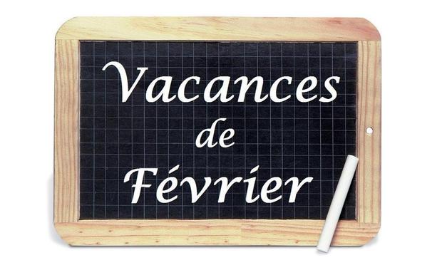 A chalkboard with the text "Vacances de Février" written in white lettering, accompanied by a piece of chalk. The board has a wooden frame and a grid pattern in the background.