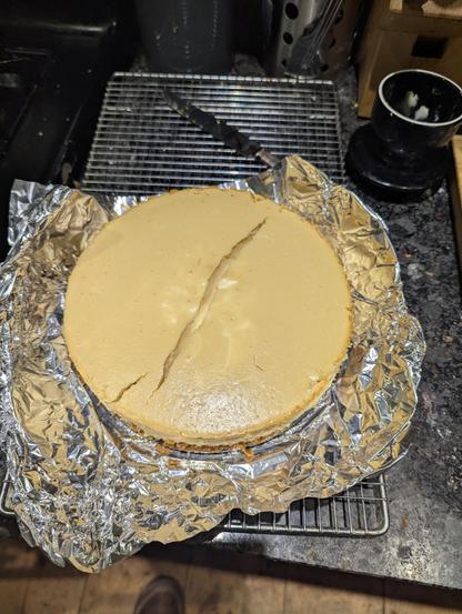 Cheese cake out of the spring form with a large crack down the centre