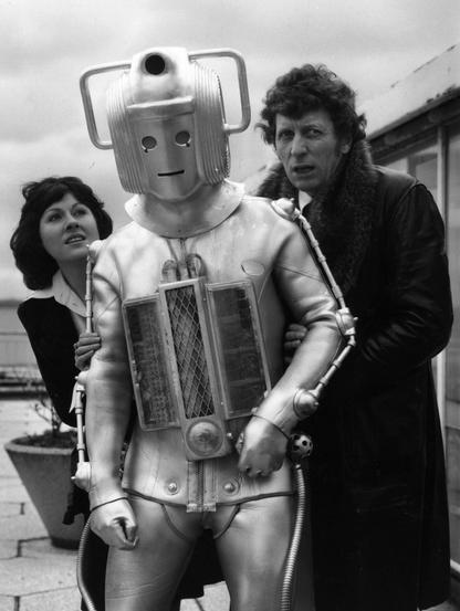 Friday, 15th February, 1974: Elisabeth Sladen and a slightly shabby Cyberman join Tom Baker on the patio outside the BBC Television Centre restaurant as the new Doctor is introduced to the press.