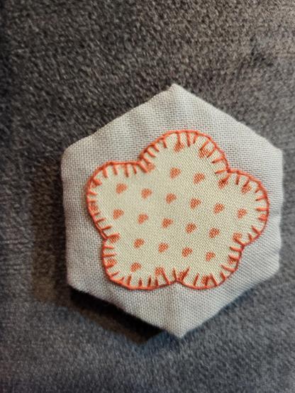 Hexagon genäht und darauf eine Blume aus Herzchenstoff mit der Hand  appliziert