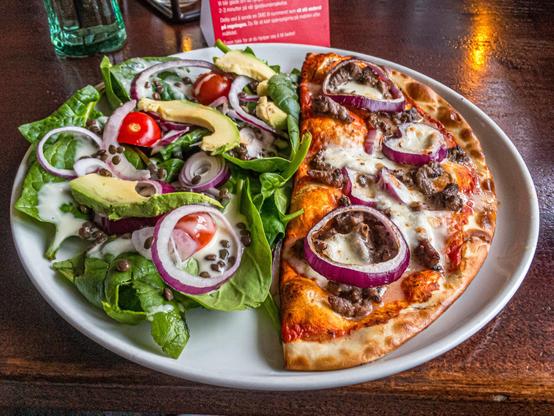 Teller mit halber Pizza und Salat