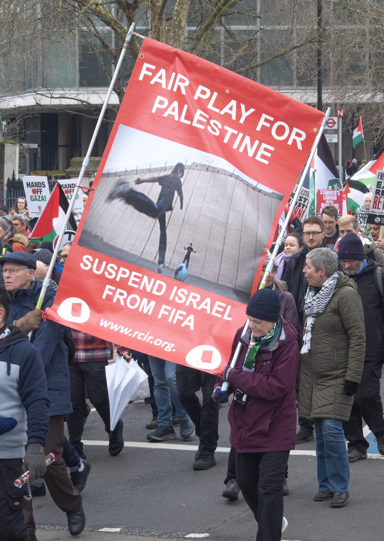 large red banner saying 'fair play for Palestine: suspend Israel from FIFA. This was made by RCIR.org, aka Rochester community inclusive rowing