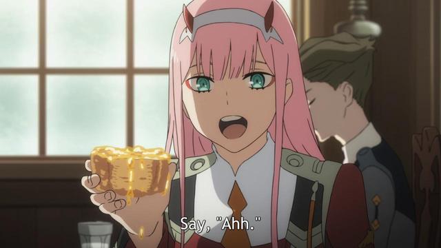 A girl (Zero Two) with pink hair and small red horns saying, “Say, “Ahh.” while holding the piece of bread.