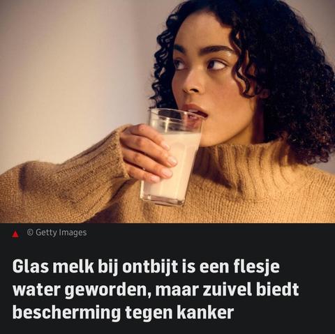 Een persoon met donkere krullen en een beige trui drinkt een glas melk en kijkt opzij. Onder de afbeelding staat de tekst: "Glas melk bij ontbijt is een flesje water geworden, maar zuivel biedt bescherming tegen kanker.