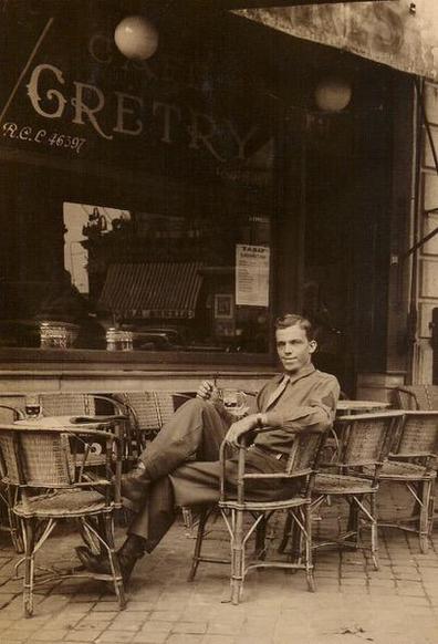 A dapper young soldier in his uniform sitting on a chair at a Café in Belgium in 1945.
