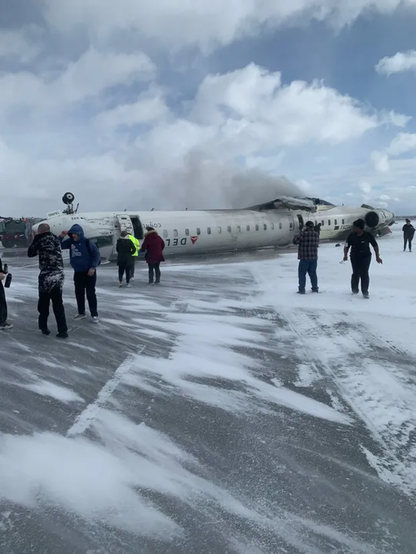 Photo of the upside down plane with wings missing. Survivors escaping. 