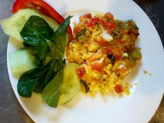 Ein Teller mit einem kleinen Frühstück für die Besucher von Retten Teilen Helfen. Ein Gemüse-Mix mit Ei, garniert mit Gurke, Feldsalat und eine roten Paprika. Alle Lebensmittel sind gerettet und werden an Bedürftige verteilt.