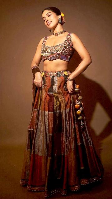 Bhumi Pednekar captivates in a black metallic lehenga by Aum, featuring a sleeveless blouse with multicolor embroidery, sequins, and beadwork. The flared silk skirt combines different hues with delicate embroidery at the waistline and hemline. An elegant tissue dupatta with embroidered borders completes the look. Styled by Meagan Concessio, Bhumi accessorizes with a statement choker from Curio Cottage and matching earrings from Silver Streak.