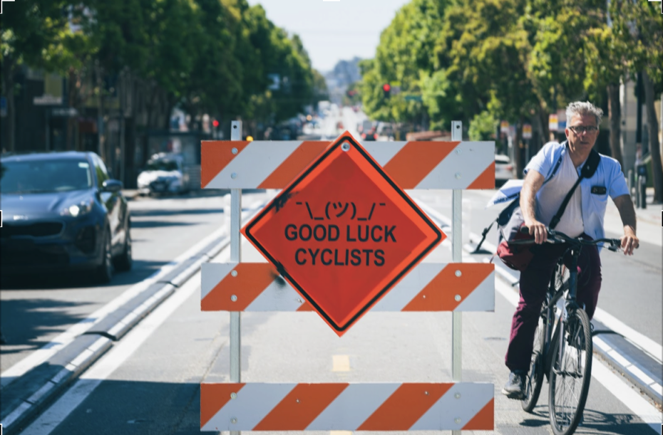 prank sign from two years ago saying "¯_(ツ)_/¯ GOOD LUCK CYCLISTS"