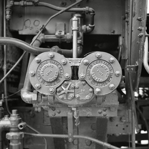 A black and white film photo. A close-up of a mechanism on the side of Locomotive 401 which is onsite at the National Ranching Heritage Center in Lubbock, Texas. Saturday, February 15, 2025.