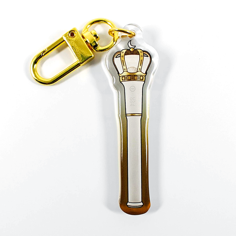 A picture of an acrylic keychain of a drawn version of Loona's newest lightstick. The rim of the keychain has an ombre that goes from gold at the bottom to clear at the top. It has a golden clasp.