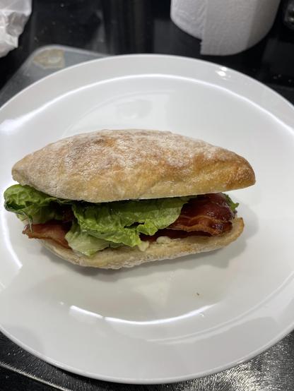 An closed BLT made with an M&S Ciabatta. Slices of crispy bacon, lettuce, and tomato can be seen in the sandwich. 
