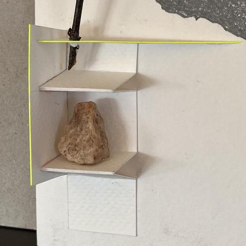 A pebble on a paper shelf