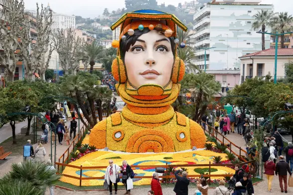 A torso of a woman made up from oranges & lemons, except for her face.