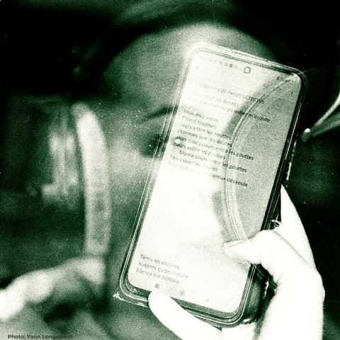 Photo en double exposition argentique,  le visage de l'artiste rappeuse devant le micro de studio et  le texte de l'artiste défilant sur son téléphone portable. Photo de Yann Longobardi