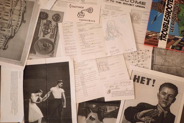 Photo de divers documents rassemblant des aides de jeux et des fiches de personnage pour The Troubleshooters, les Risques-tout un jeu de rôle. On y voit des images de l'URSS datant des années 60 environ. AInsi qu'un bout du livre de base du jeu de rôle The Troubleshooters.