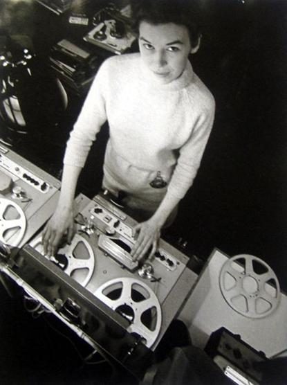 English composer Delia Derbyshire operating vintage audio recording equipment with reel-to-reel tape recorders.