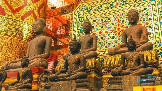 Several stone Buddha statues in a temple.