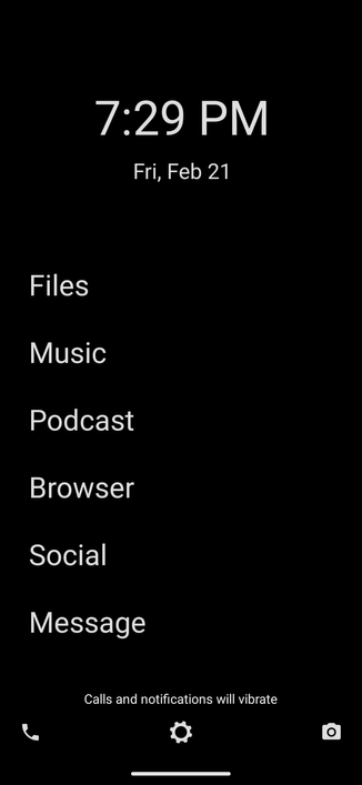 Homescree totalmente en negro con letras en blanco que muestra un menú que enlista: La hora, fecha, Files, músic, podcast, browser, social, message. En la parte inferior 3 opciones a la izquierda teléfono, al centro settings, derecha cámara