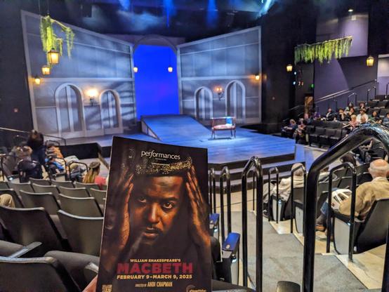 The program for the play "Macbeth" in front of the empty stage before the show starts.